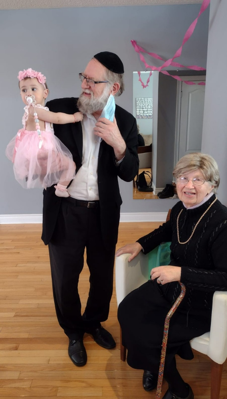 Bobby watching as a baby is lifted up mid-celebration