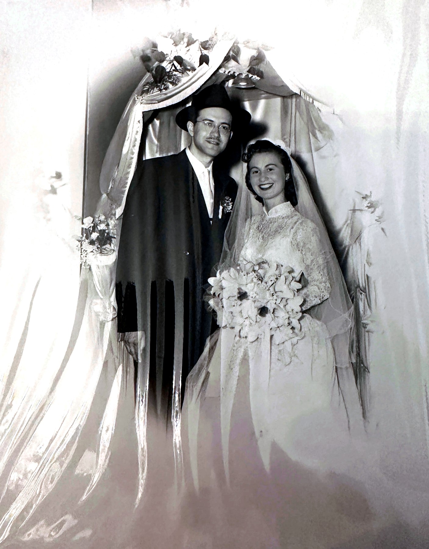 Izzy and Esther Rubenstein together under the flowered chuppah after the ceremony