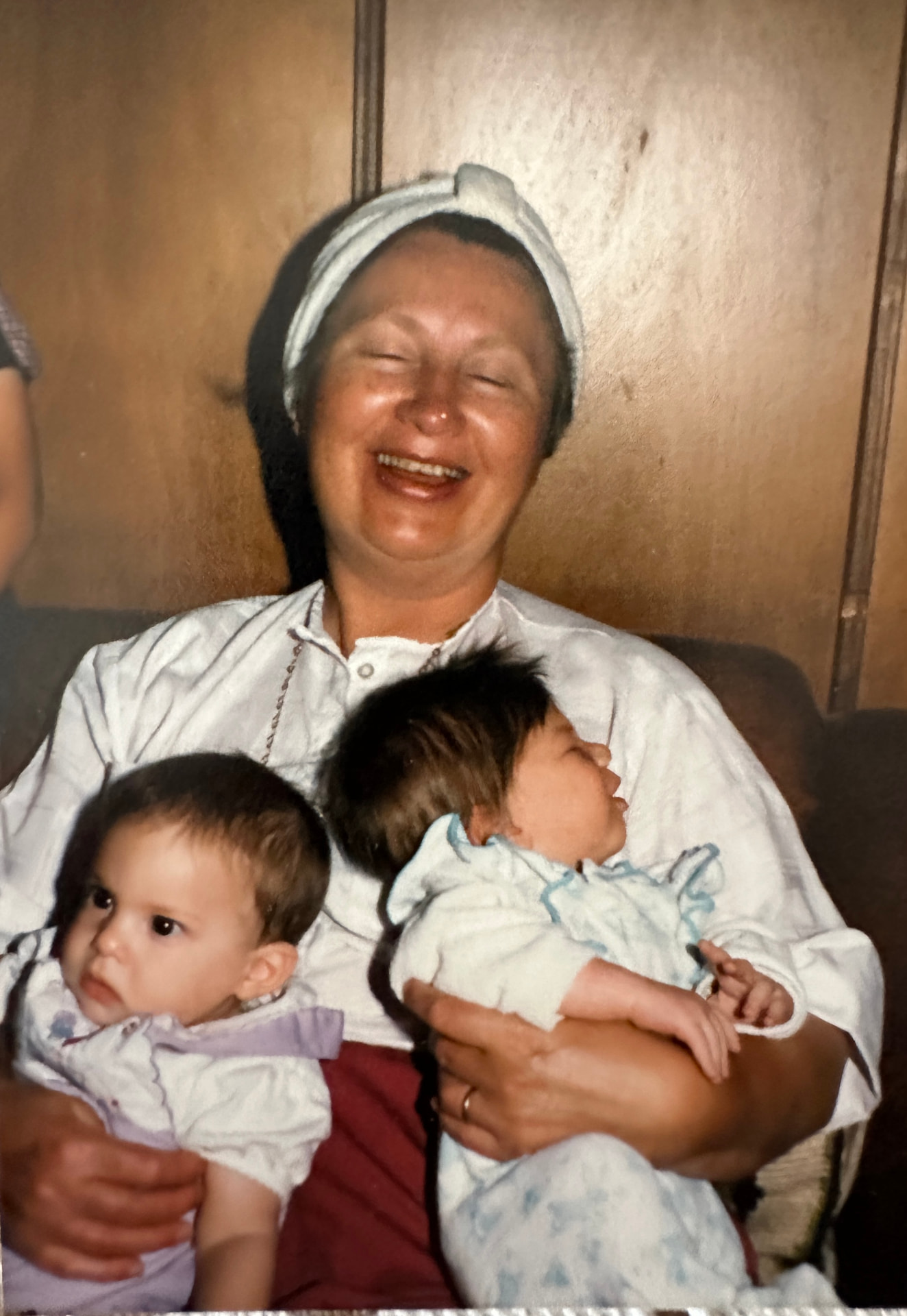 Bobby laughing with a baby in each arm