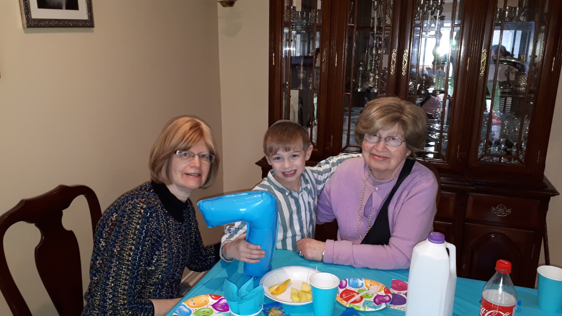 Bobby at a birthday table with her daughter and a great-grandson