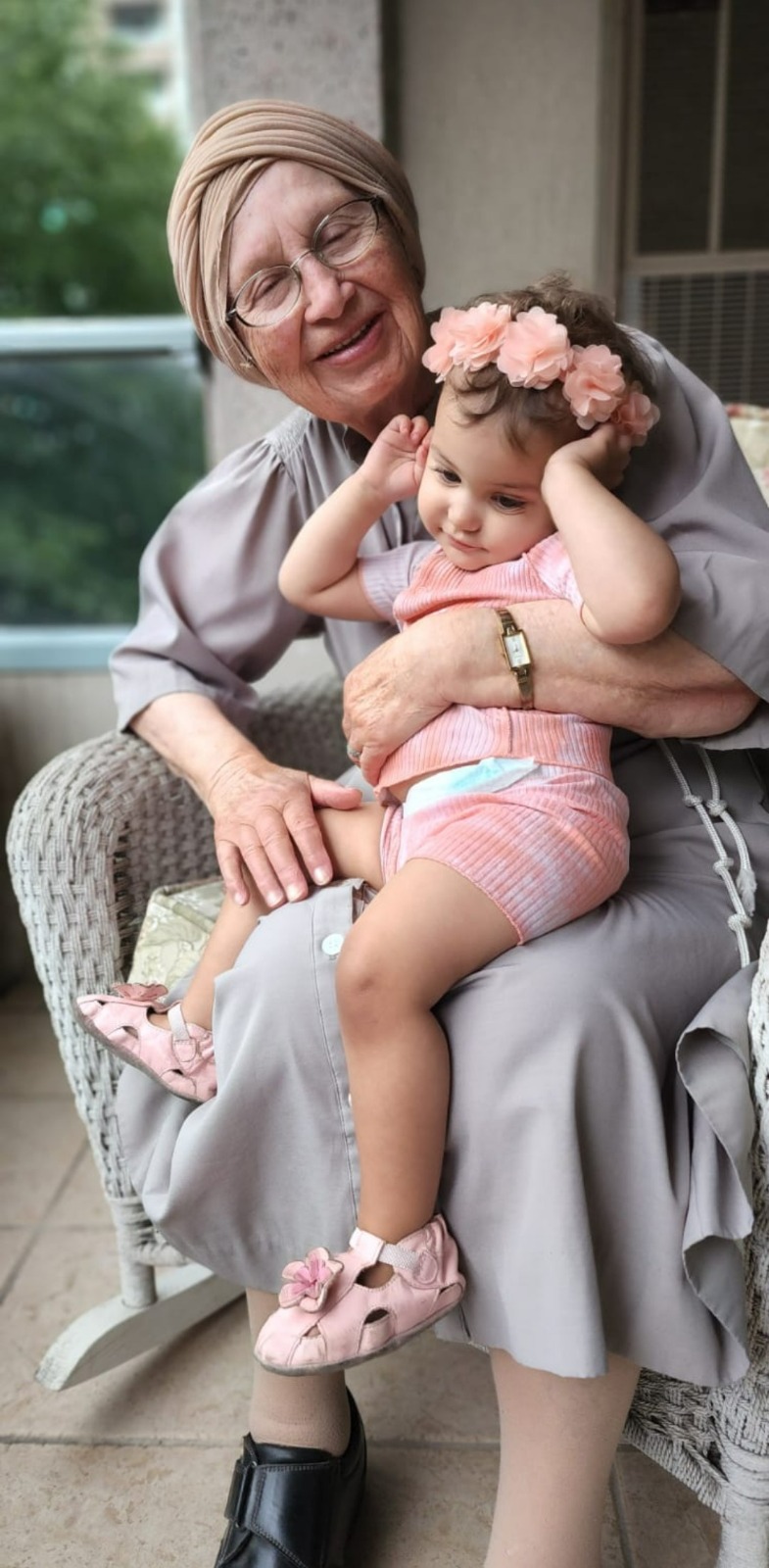 Bobby cradling a great-granddaughter on the porch