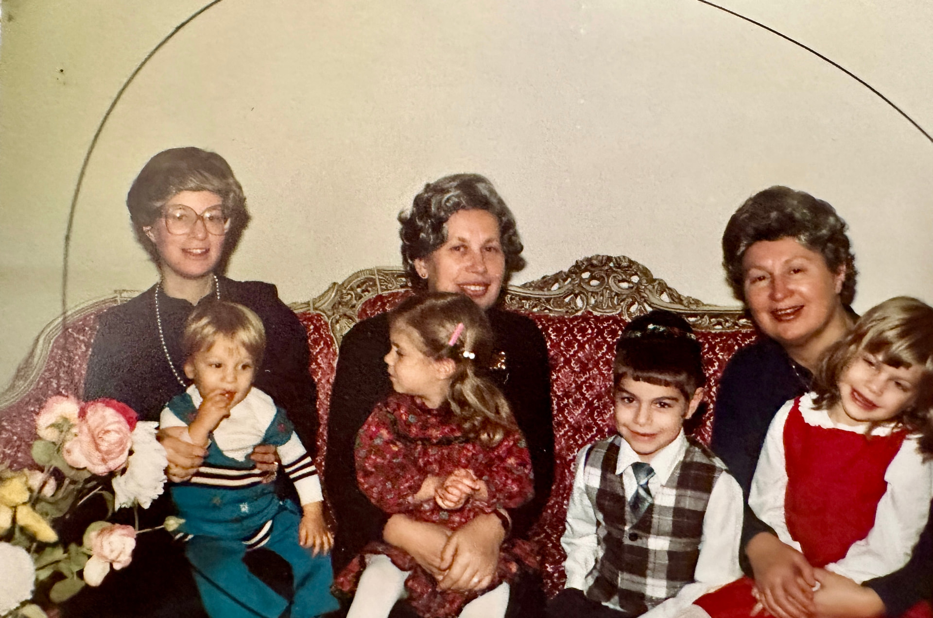 Three generations of women on the red sofa with the little ones