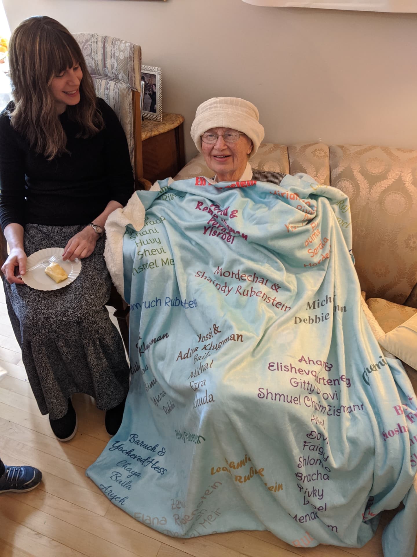 Bobby wrapped in a blanket embroidered with every family name