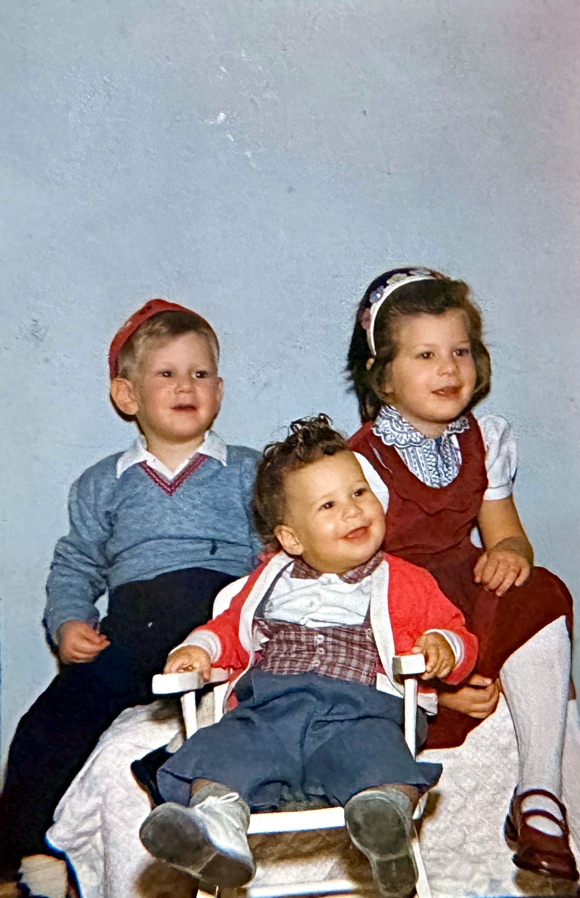 The three Rubenstein children in a blue-backdrop studio portrait