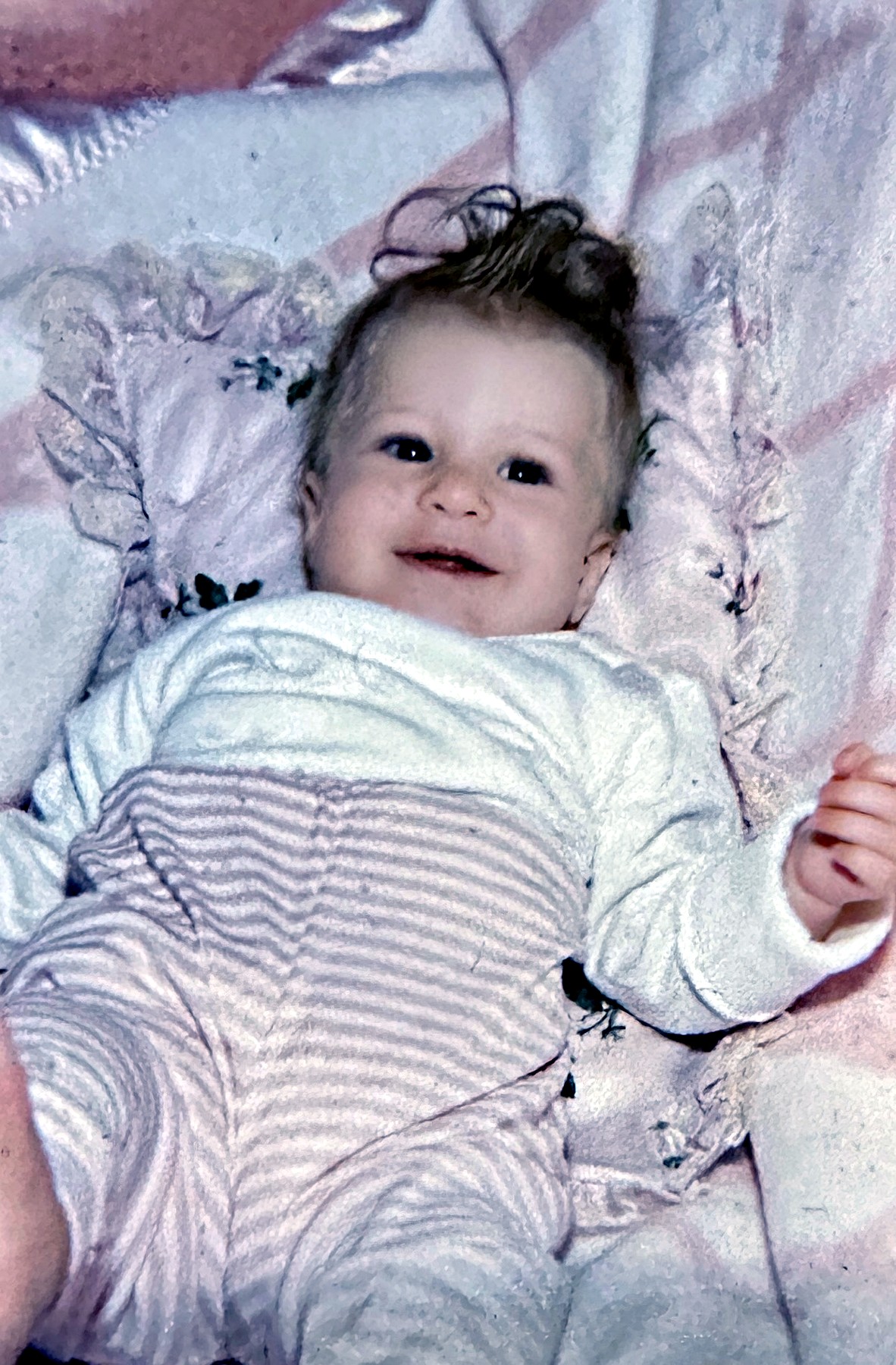 A Rubenstein baby lying on a pink blanket looking up at the camera